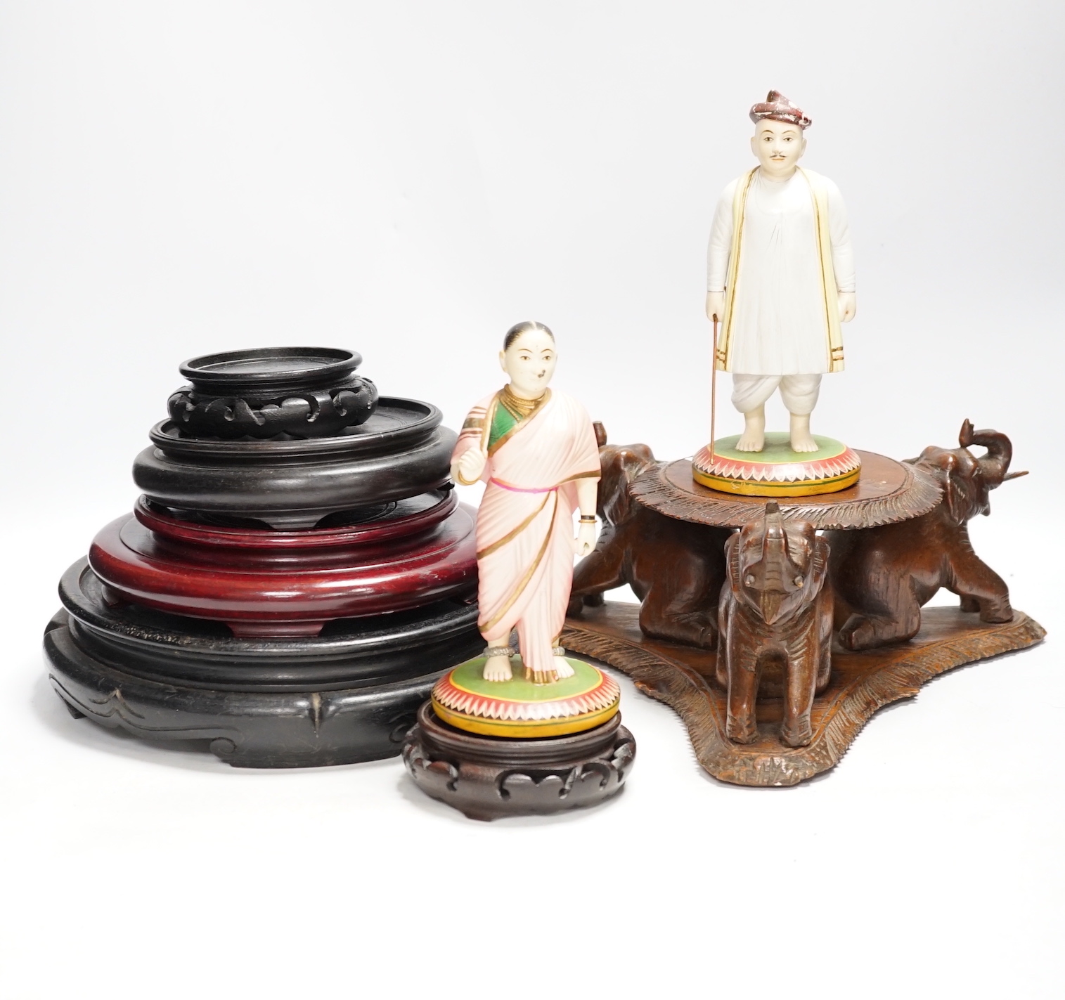 Two Indian carved and painted wood figures, an Indian or Burmese carved wood stand another various wood stands, largest 24cm in diameter